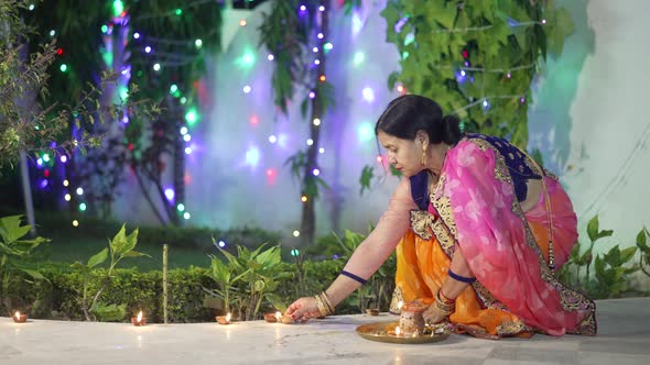 A Women Lighting a Lamp