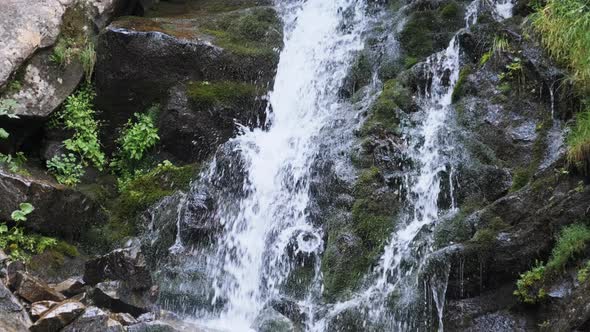 Wild Mountain Waterfall. Rapid Falling Water Hitting on the Stones. Slow Motion alt