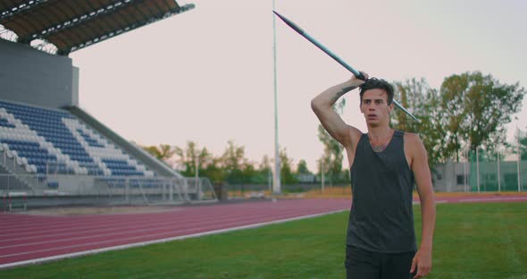 Slow-motion: a Male Athlete at the Stadium Concentrates Runs Up and Throws a Javelin. Preparation