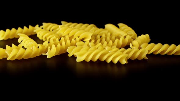 Macaroni Pasta Falling Down black background, slow motion