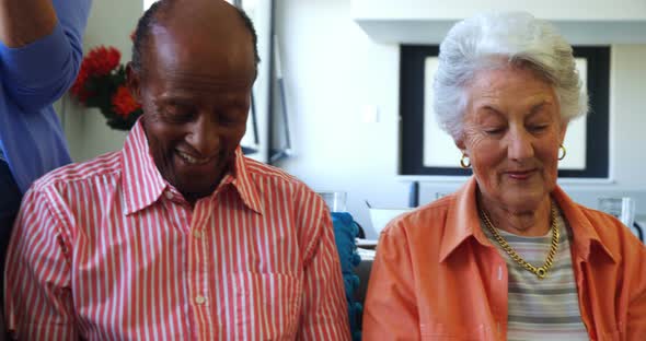 Happy senior friends using digital tablet on sofa alt