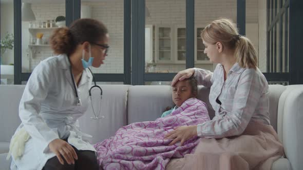 African Family Doctor Visiting Sick Child at Home alt