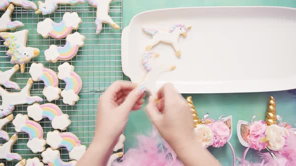 Unicorn sugar cookies decorated with royal icing on a blue background. alt