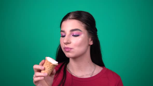 Young Cute Woman Eating Ice Cream Enjoying Sweets Isolated on Blue Background