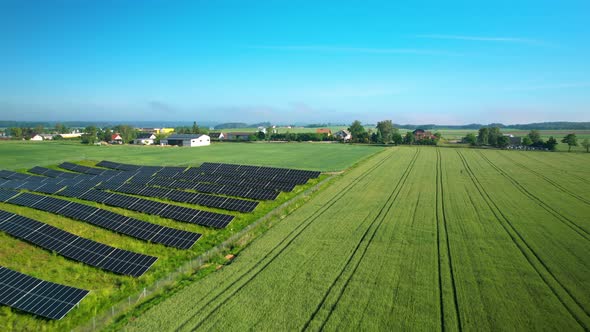 Flying Over Solar Panels And Green Fields In The Countryside  - aerial drone shot alt