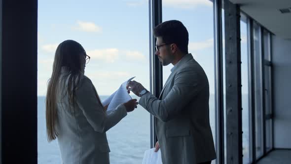 Two Professionals Checking Papers at Sea View alt