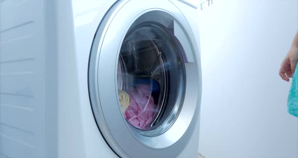 Close Up Industrial Washing Machine Washes Colored Clothing and White Linen, White Striped Clothing alt