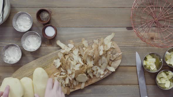 Flat lay. Peeling organic yellow potatoes with potato peeler alt