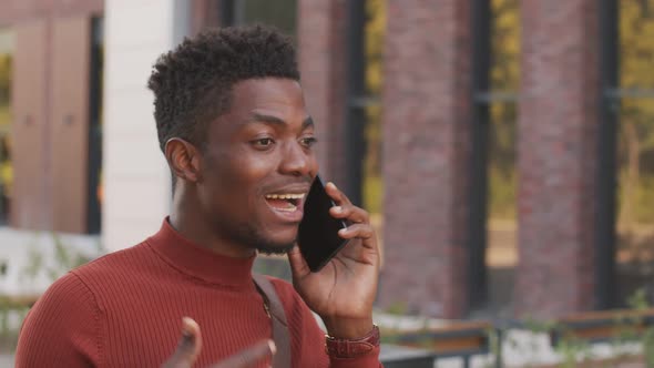 African American Man Chatting on Phone Outdoors alt