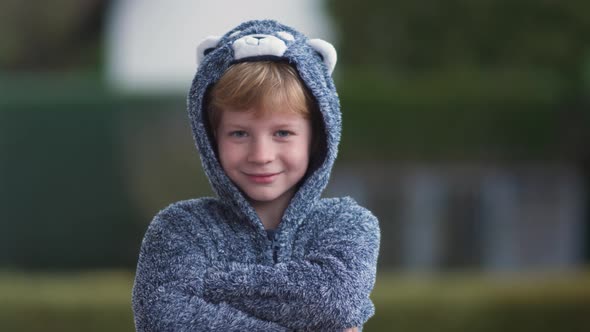 Funny young boy in bear suit has fun on camera