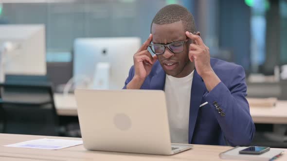 Young African Businessman with Laptop Having Headache alt