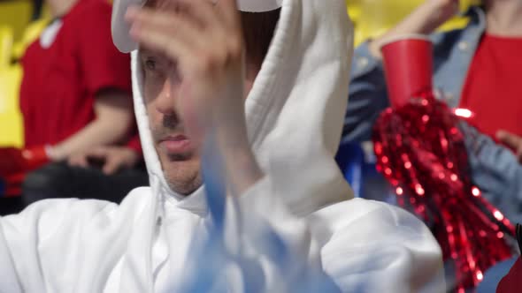 Young Fans Cheering and Discussing Match at Stadium alt