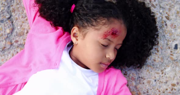 Unconscious girl fallen on ground after accident alt