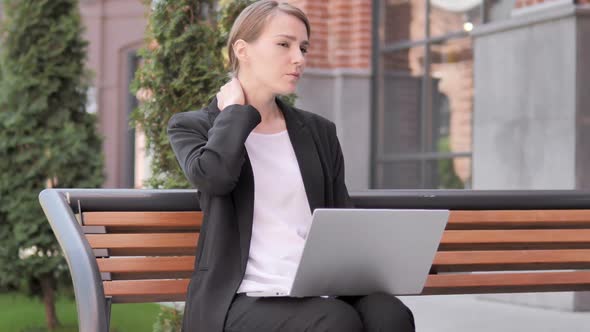 Young Businesswoman with Neck Pain Using Laptop Outdoor alt