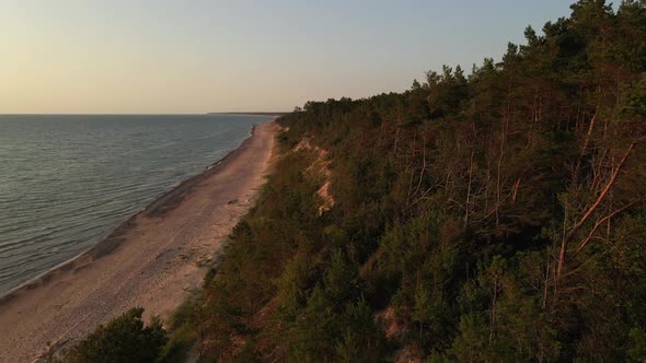 Aerial Forward: Beautiful Sunset at Baltic Sea with Latvian Forest and Sand Precipice alt