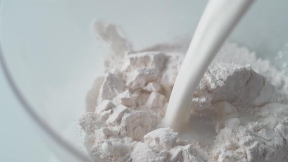 Pouring milk on a pile of flour. Slow Motion. alt