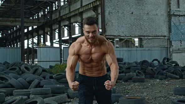 Shirtless bodybuilder posing outdoor. Handsome muscular model posing outdoors alt