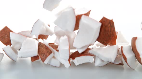 Super Slow Motion Shot of Fresh Coconut Pieces Falling on White Background at 1000Fps alt