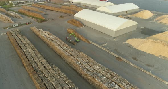 Tree Logs in Timber Terminal Port Crane Unloading Logging Truck Aerial View alt