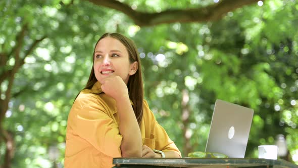 Inspired Female Freelancer Using Laptop Outdoors