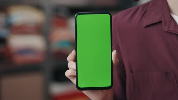 Caucasian Woman Holding Smartphone with Green Mock Up Screen and Showing It to the Camera While alt