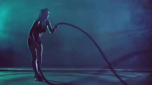 Muscular Brunette Woman Training with Ropes alt