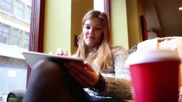 Woman in a London cafe looking at digital tablet