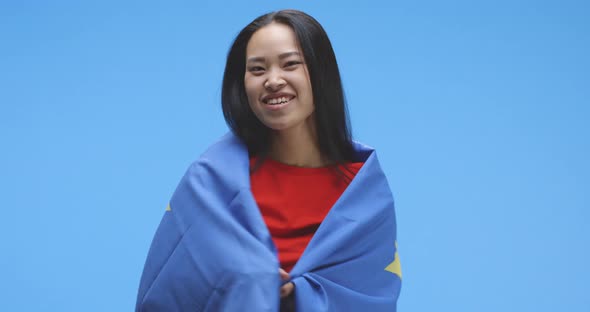 Young Woman Wrapped in and Dancing with Eu Flag alt