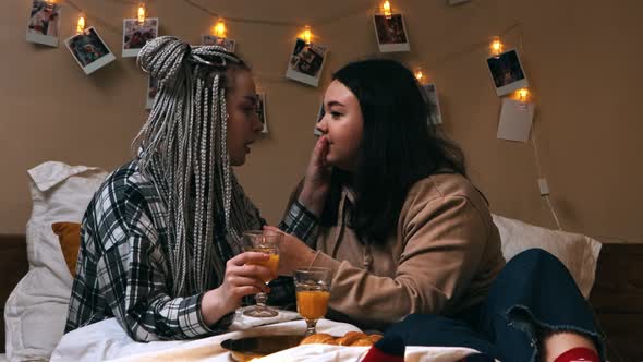 A Young Woman Brings Breakfast To Her Girlfriend in Bed  Drinking Juice and Playing with Dreadlocks alt