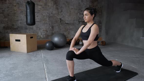 Sporty young woman making squats for glutes in side lunge training. Athletic fit girl doing fitness  alt