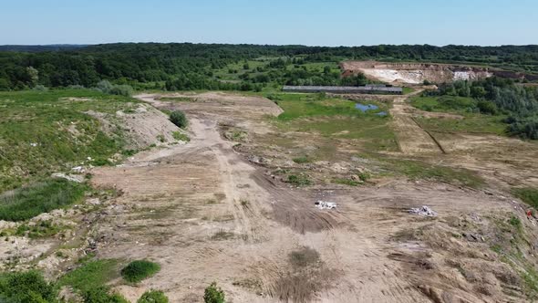Aerial drone view of a flying over the technogenic landscape among rural agricultural fields. alt