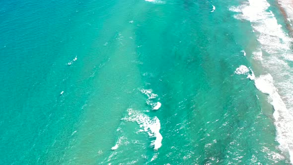 A cool drone shot of crystal clear waves rolling into a South Florida Beach. alt