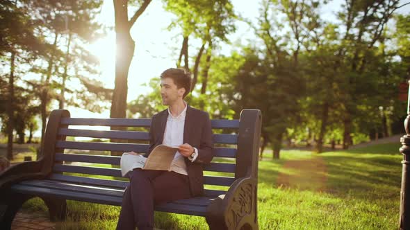 Handsome Businessman Office Worker Salesmen Resting in Park Sitting on Bench Happy and Reading