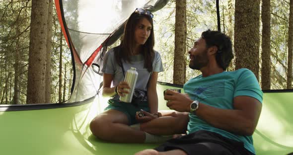 Two Man Woman People Drinking on Hanging Tent Camping in Sunny Forest