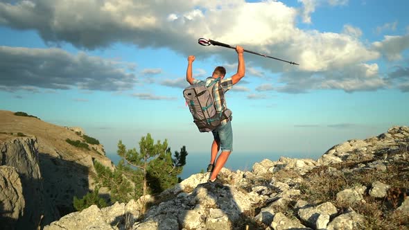 Male Hiker in Backpack and Trekking Poles Reaching Up Top of Mountain Hike Travel and Raise Hands alt