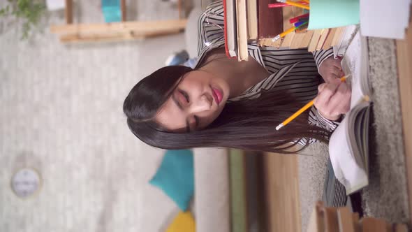 Asian Student Is Preparing for the Exam Lying on the Floor with a Laptop and Booksvertical Video alt
