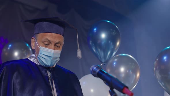 University Male Professor in Gown and Medical Mask are Solemnly Presenting Diplomas to Students alt