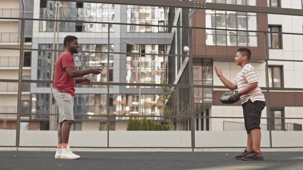 Father and Son Having Baseball Training Outdoors alt
