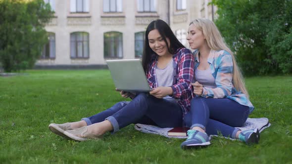 Female Friends Watching Video on Laptop and Discussing Last Student's Party alt