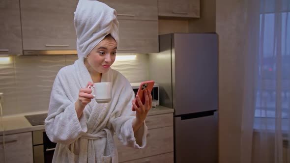 Girl in Bathrobe with Towel on Her Head Uses Phone for Work From Home Slow Motion