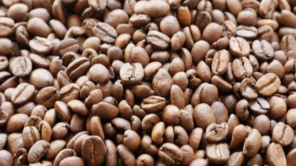 Dark fresh roasted arabica coffee beans on table slow tilt 4K 2160p 30fps UHD video - Slow tilting o alt