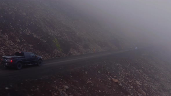 Pick-up Truck Drive Into Mountain Roads During Foggy Morning In Westfjords, Iceland. - Tracking Shot alt