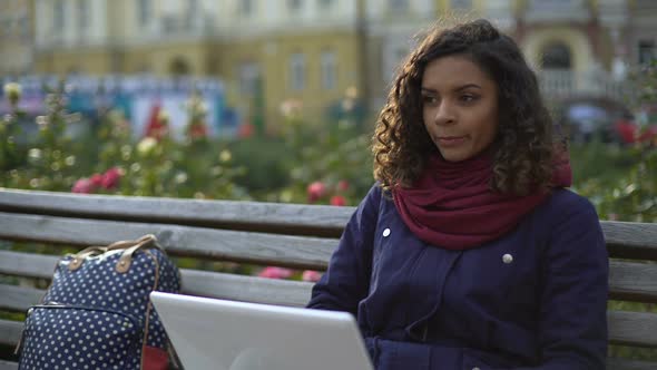 Female Student Studying on Laptop Outdoors, Writing Essay, Blogging for Website alt