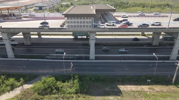 Vehicles cruising road underneath Highway with toll Gate. urban infrastructure alt