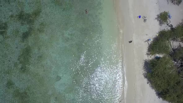 Coastal strip full of umbrellas and sun bed Tranquil aerial view flight tilt up drone footage of Gi alt