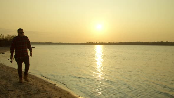 Male Angler Walking on Lake Shore at Dawn