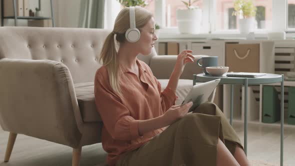 Woman Sitting on Floor with Tablet alt