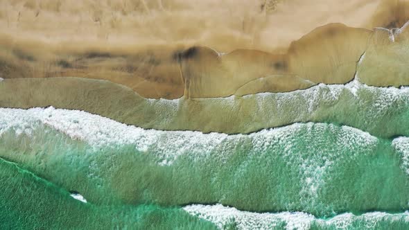 Aerial vertical View on the tropical sand Beach with Splashing Sea Waves