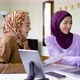 Two asian muslim women working together with using laptop pc tablet and paper graphic chart - VideoHive Item for Sale