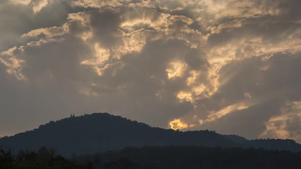 Time-lapse of Clouds and sunbeam over the mountain during sunset.